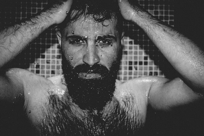 man with body hair standing in shower